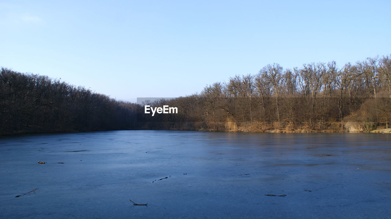 SCENIC VIEW OF LAKE AGAINST CLEAR BLUE SKY DURING WINTER