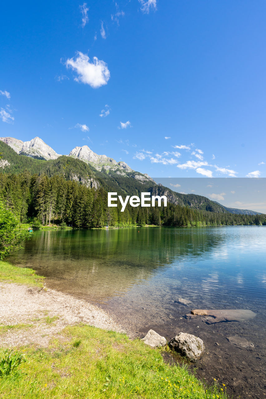 Scenic view of lake by mountain against sky