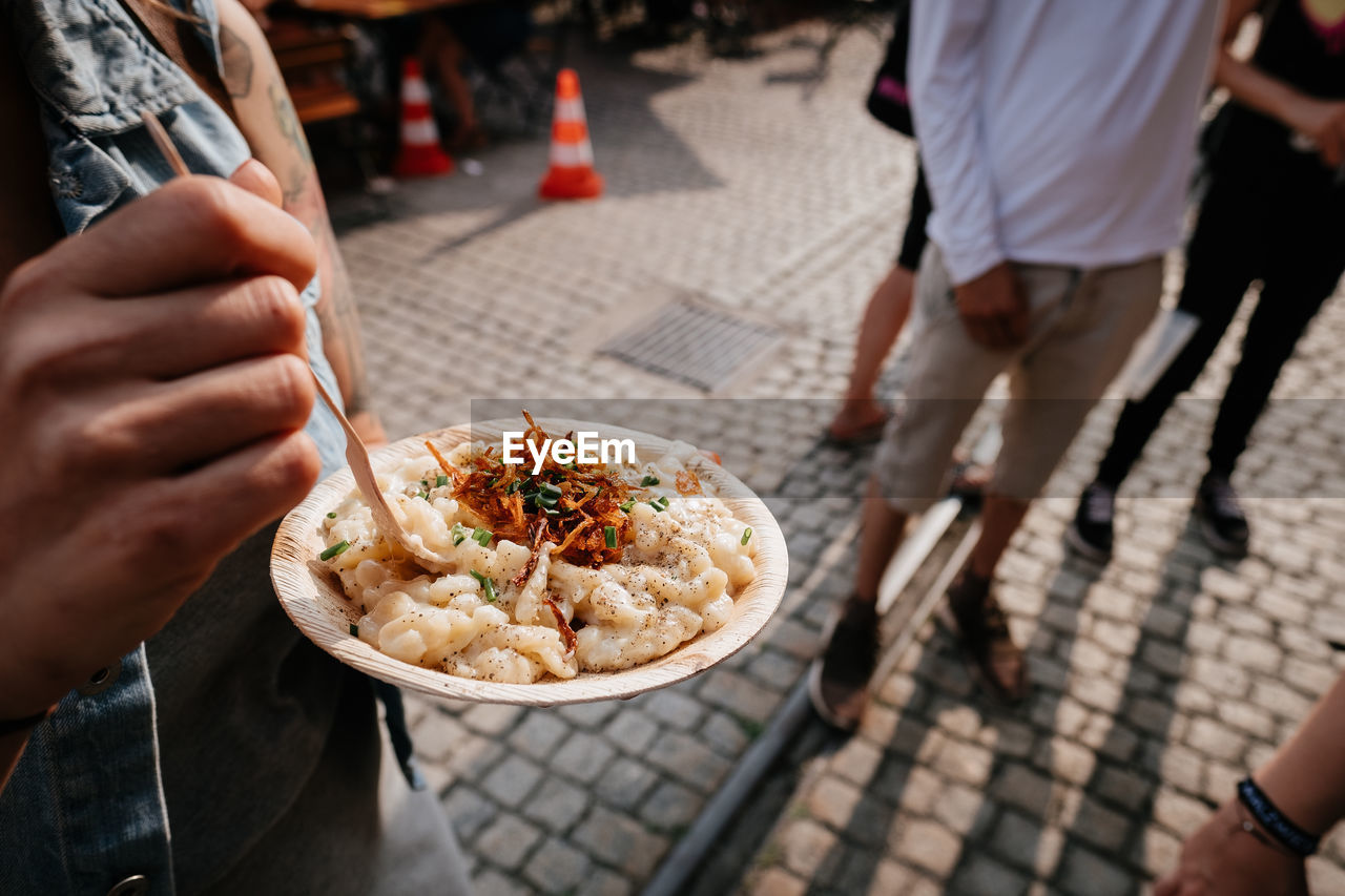 Midsection of woman eating food on street