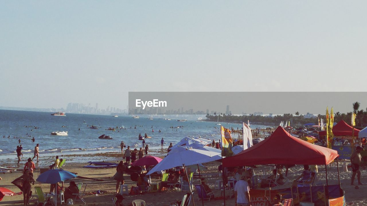 People at beach against sky