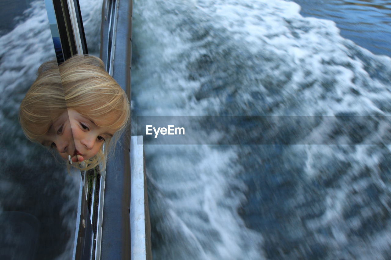 Girl looking through window of ship