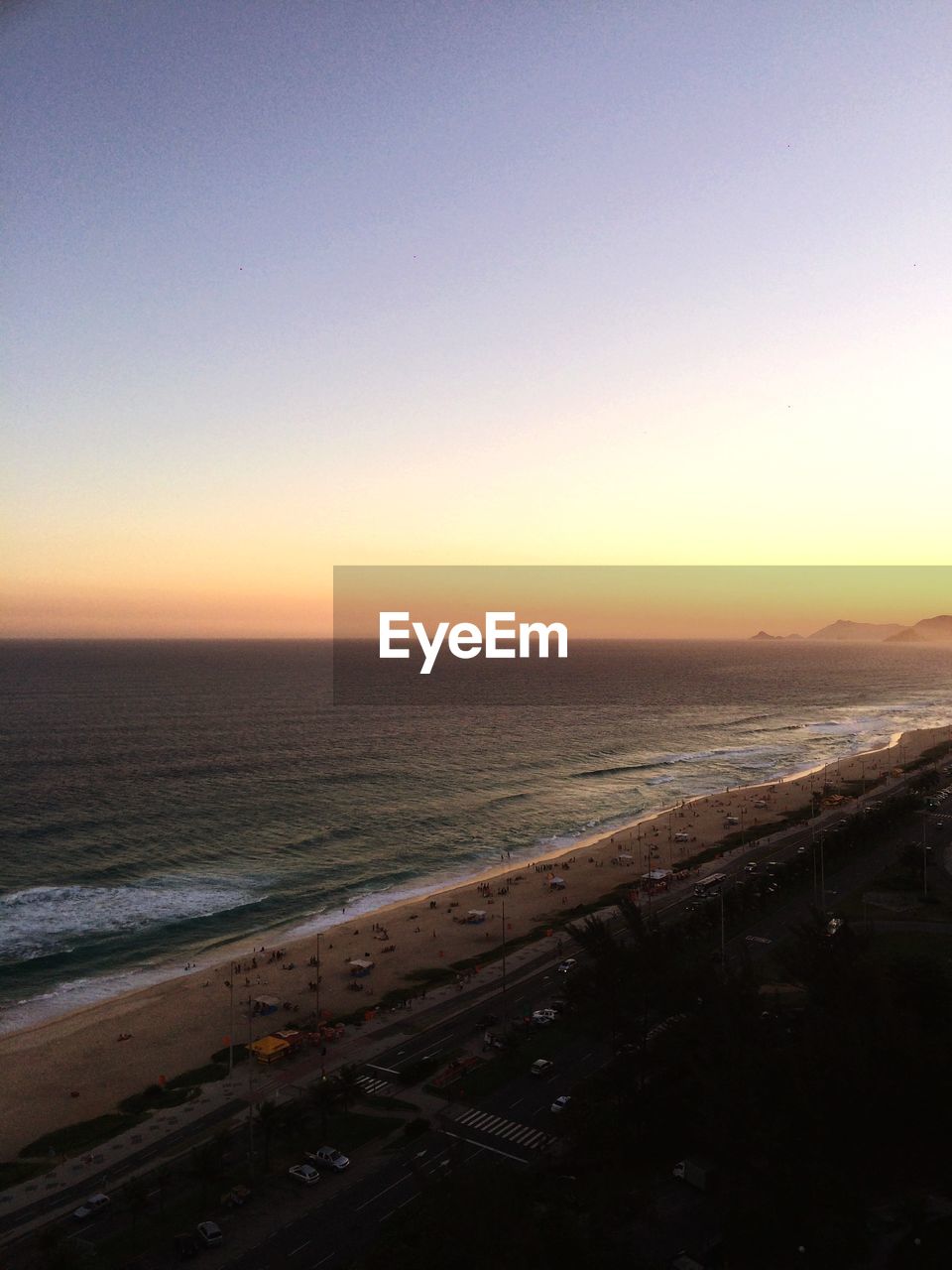 Scenic view of beach and sea against sunset sky