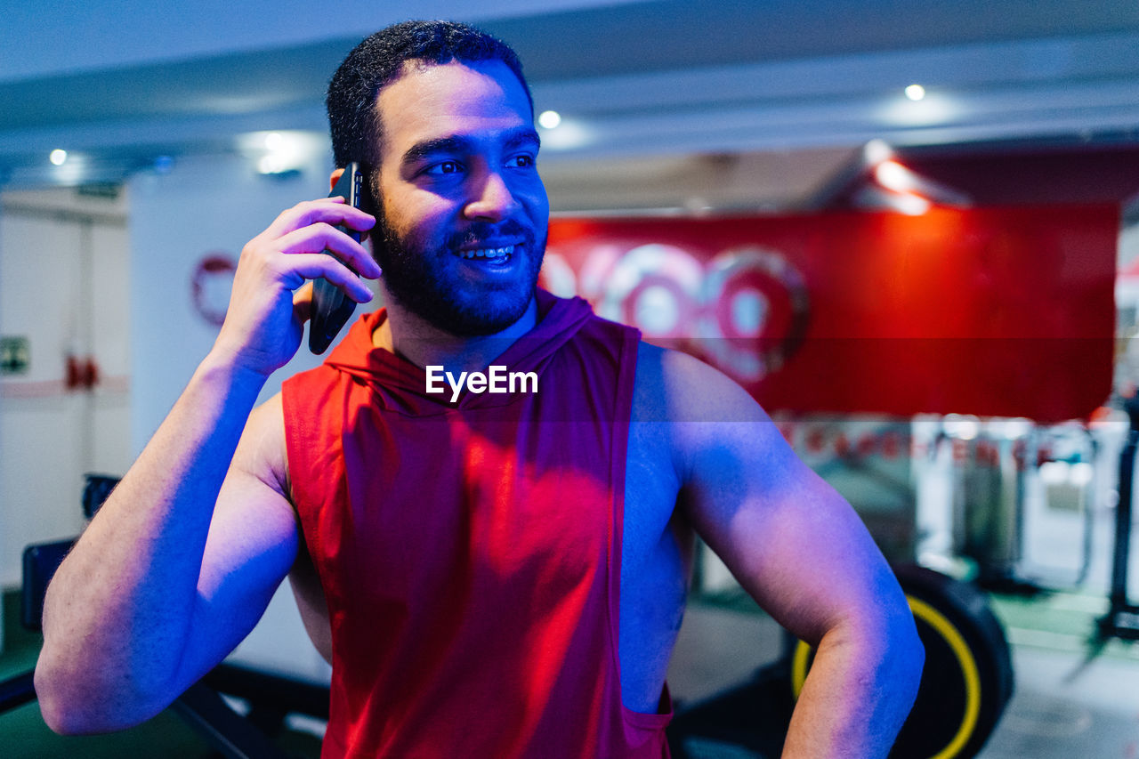 portrait of young man wearing sunglasses while standing in gym