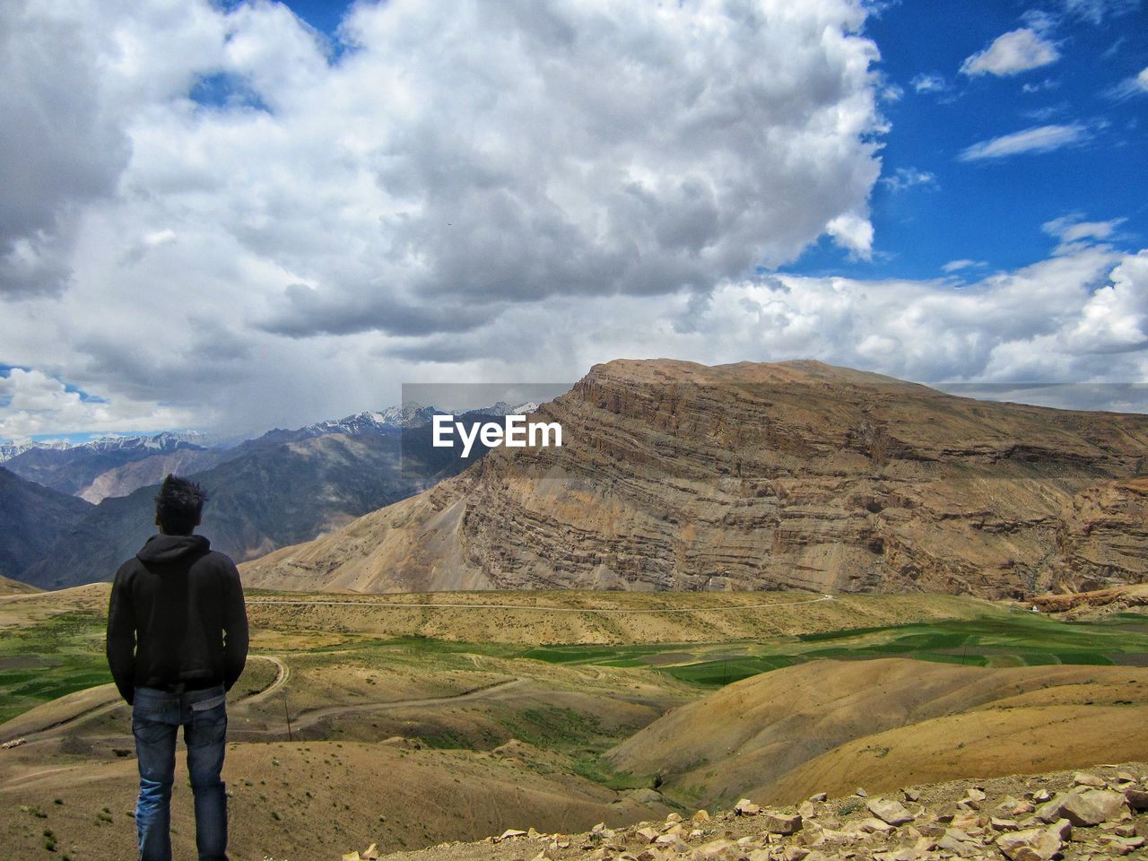 REAR VIEW OF MAN LOOKING AT MOUNTAINS