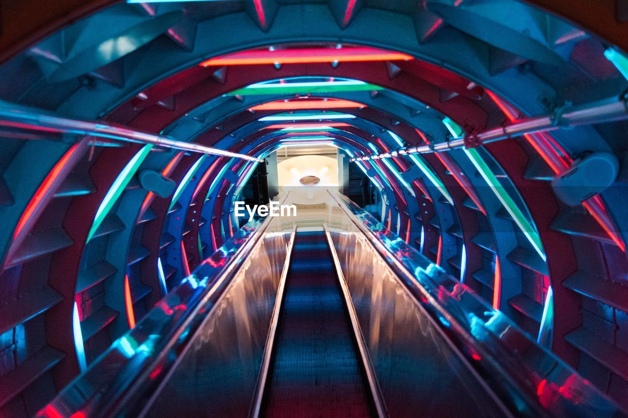Moving walkway with colorful lights in tunnel