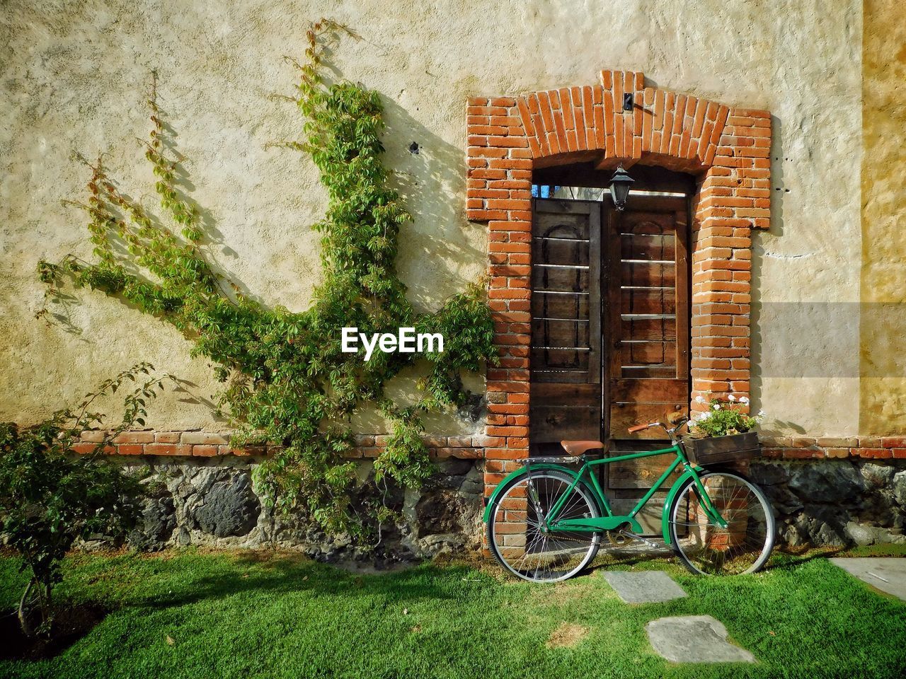 BICYCLE AGAINST BRICK WALL OF HOUSE