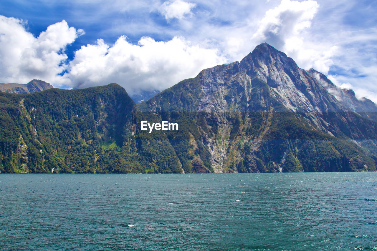 Scenic view of sea and mountains against sky