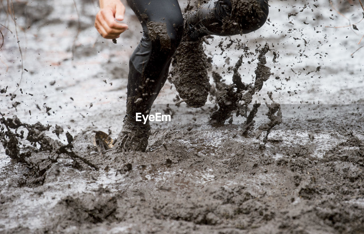 Low section of man running in mud