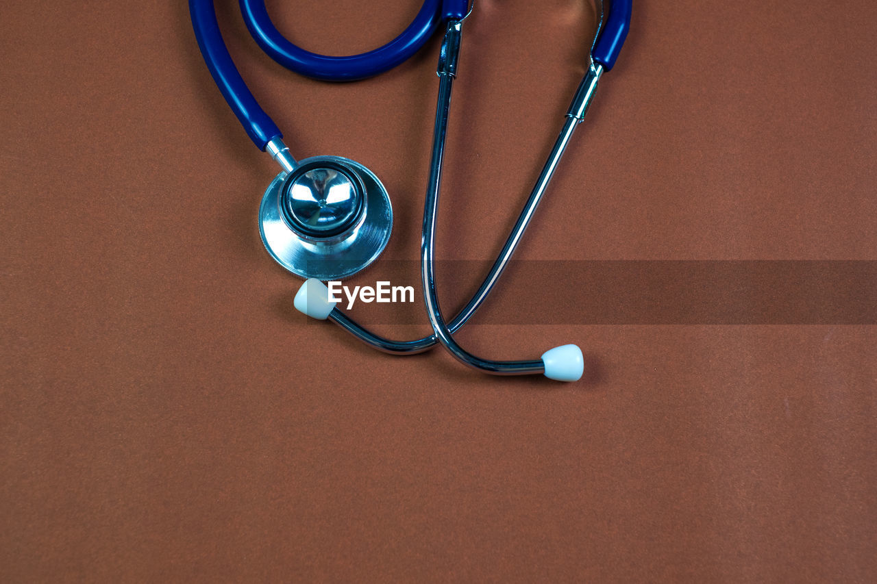 HIGH ANGLE VIEW OF EYEGLASSES ON TABLE AGAINST WALL