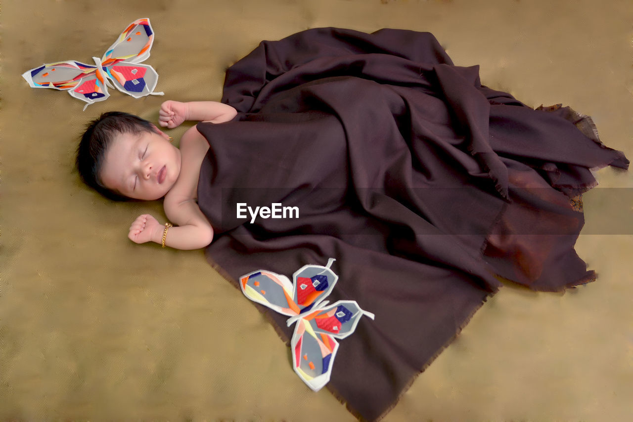 High angle view of cute baby girl sleeping on bed