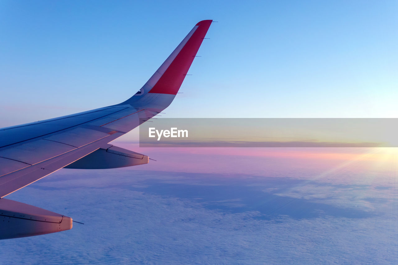 AIRPLANE FLYING OVER SEA AGAINST SKY