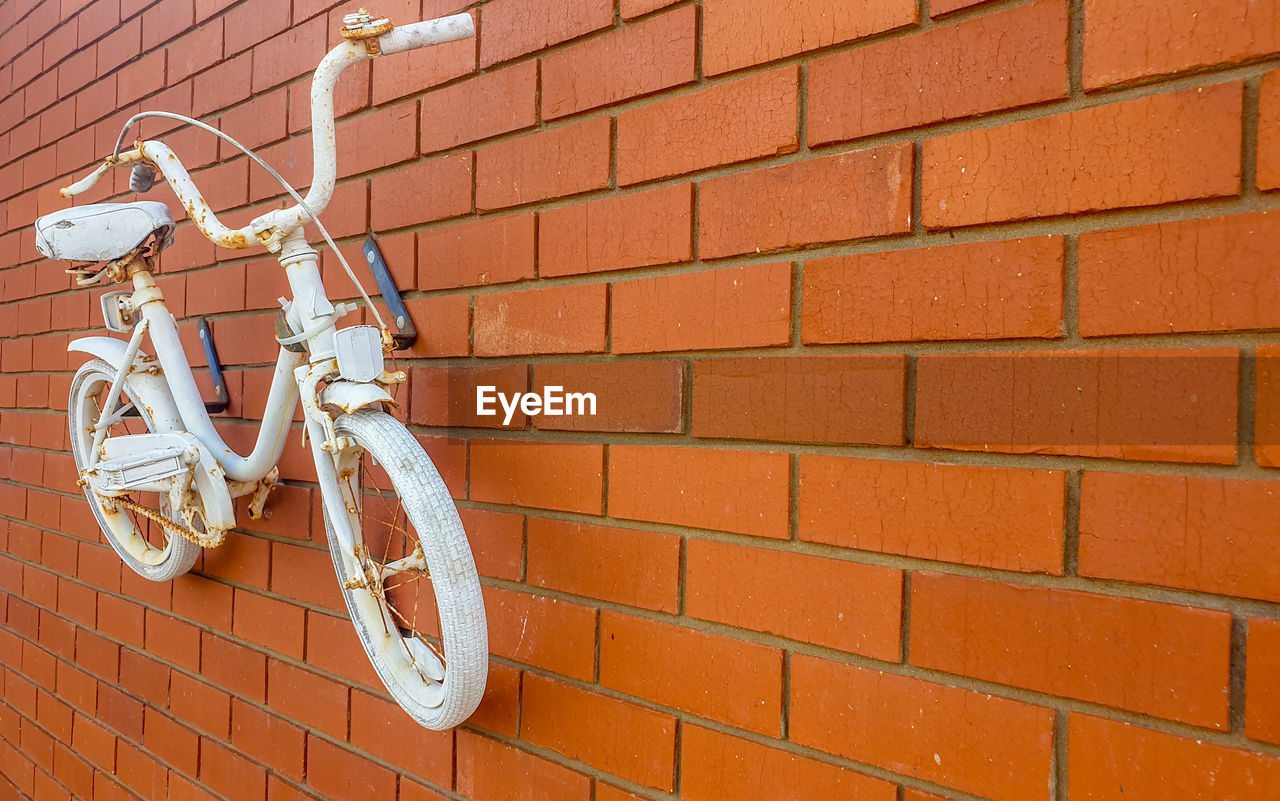 CLOSE-UP OF BICYCLE AGAINST BRICK WALL