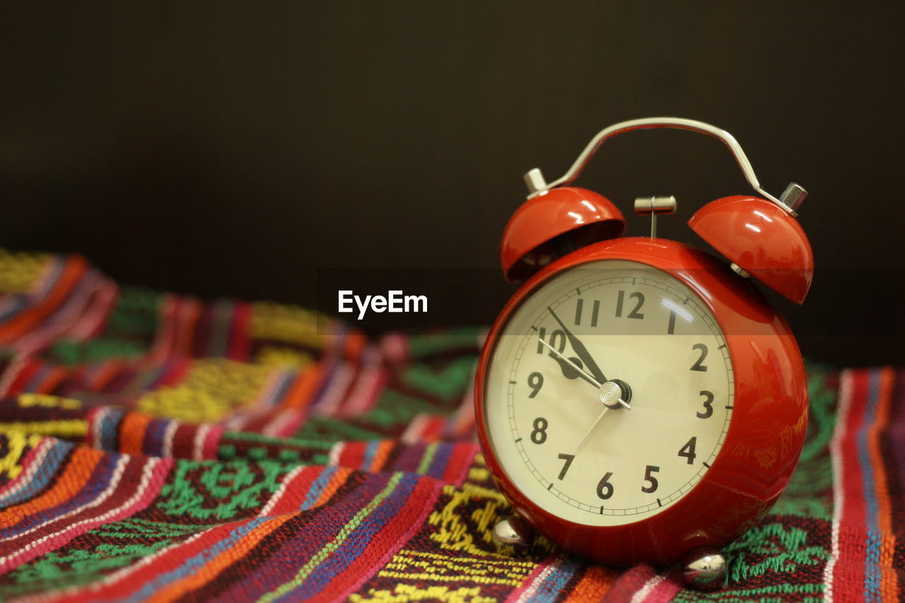 CLOSE-UP OF CLOCK AGAINST BLURRED BACKGROUND