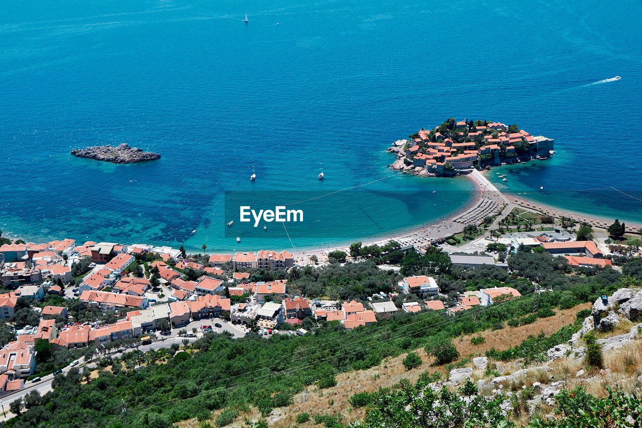 HIGH ANGLE VIEW OF TOWNSCAPE AND SEA BY CITY