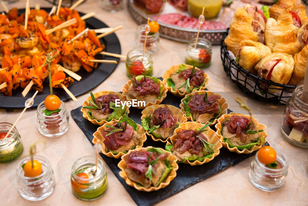 Table with lots of appetizers, buffet table, tartlets, appetizers in jars