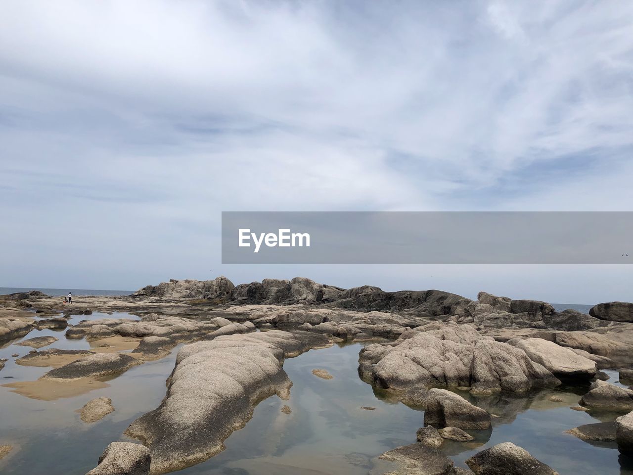 ROCKS ON SHORE AGAINST SKY