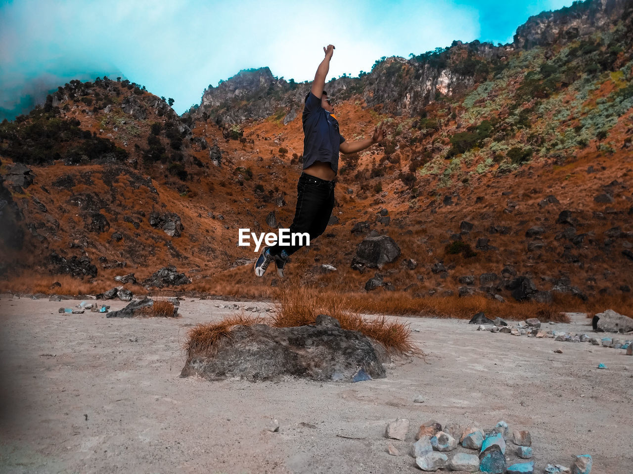 MAN JUMPING ON ROCKS