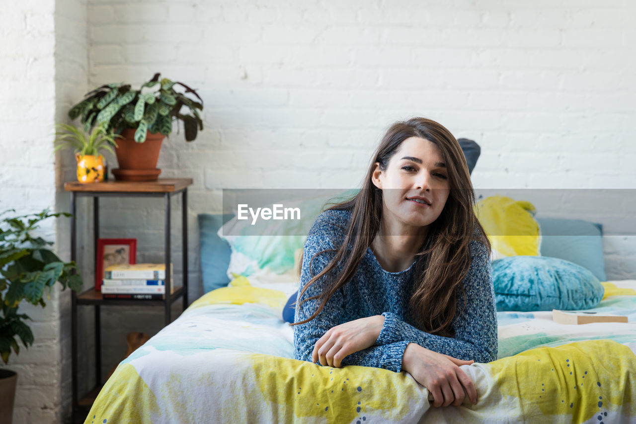 Young woman relaxing on bed in bedroom at home