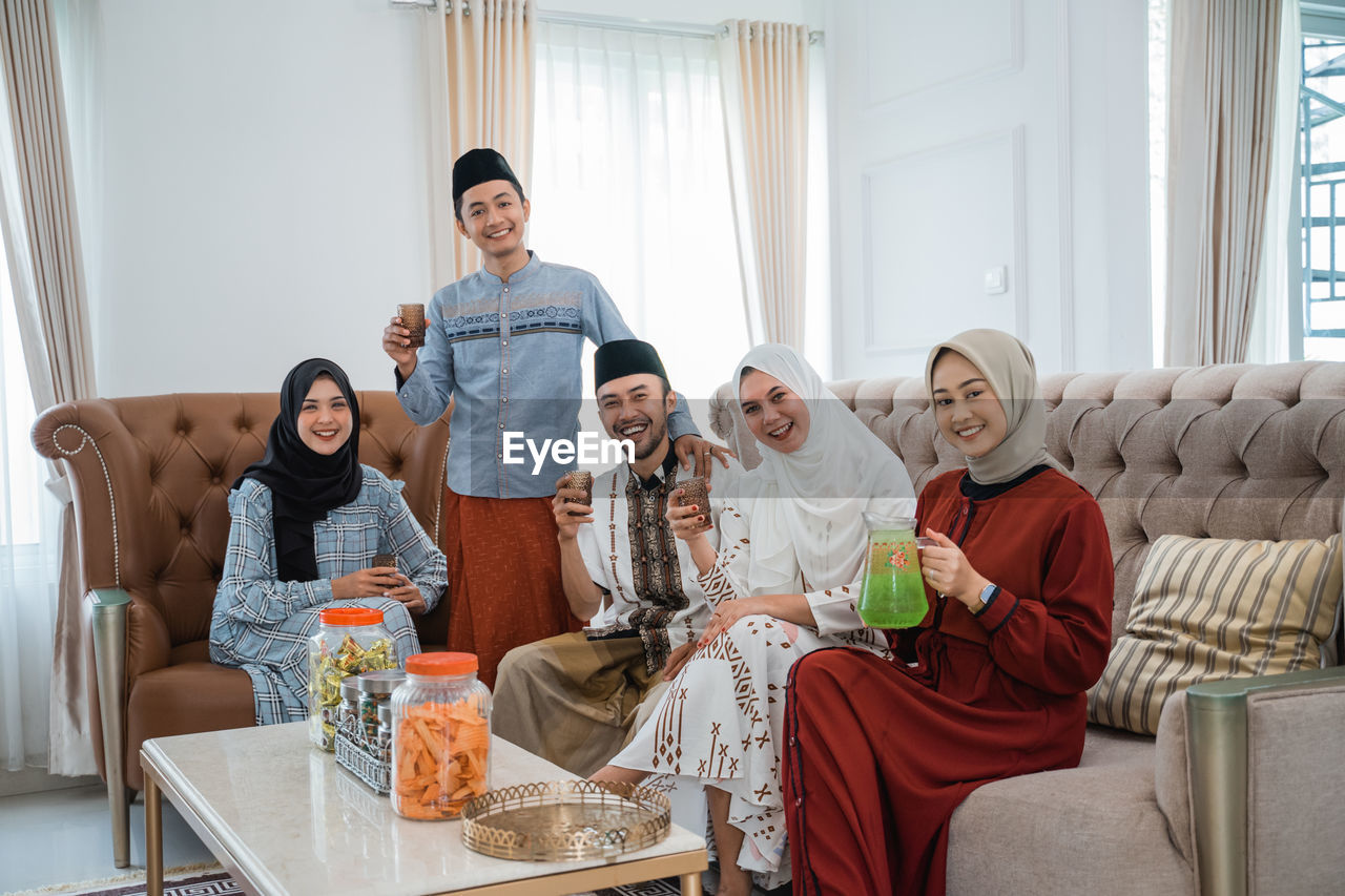 portrait of smiling family sitting on sofa