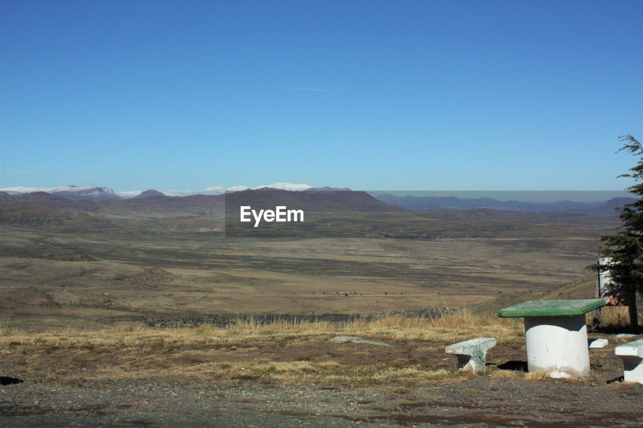 Seats on landscape against sky