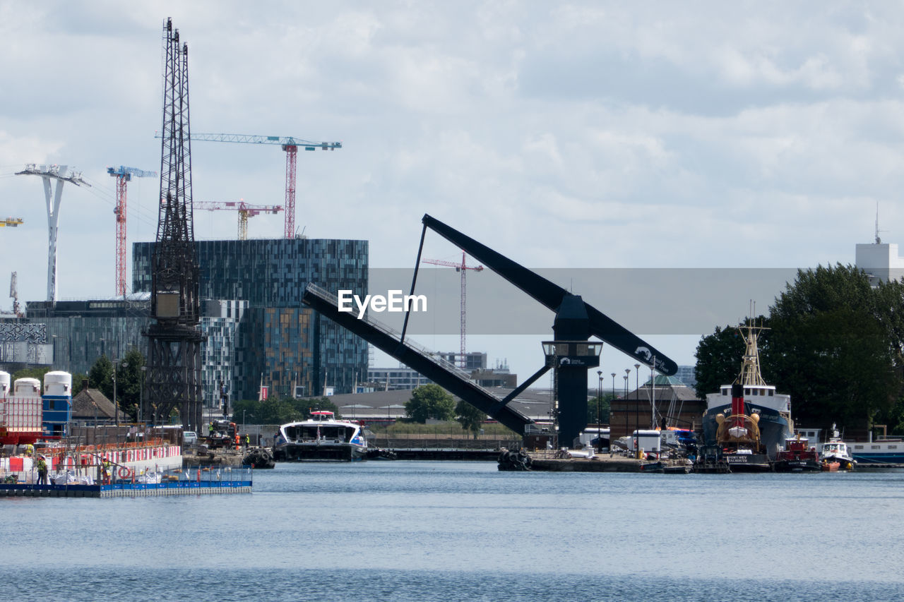 CRANES IN CITY AGAINST SKY