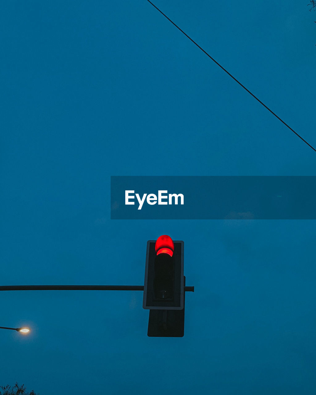 Low angle view of road signal against blue sky