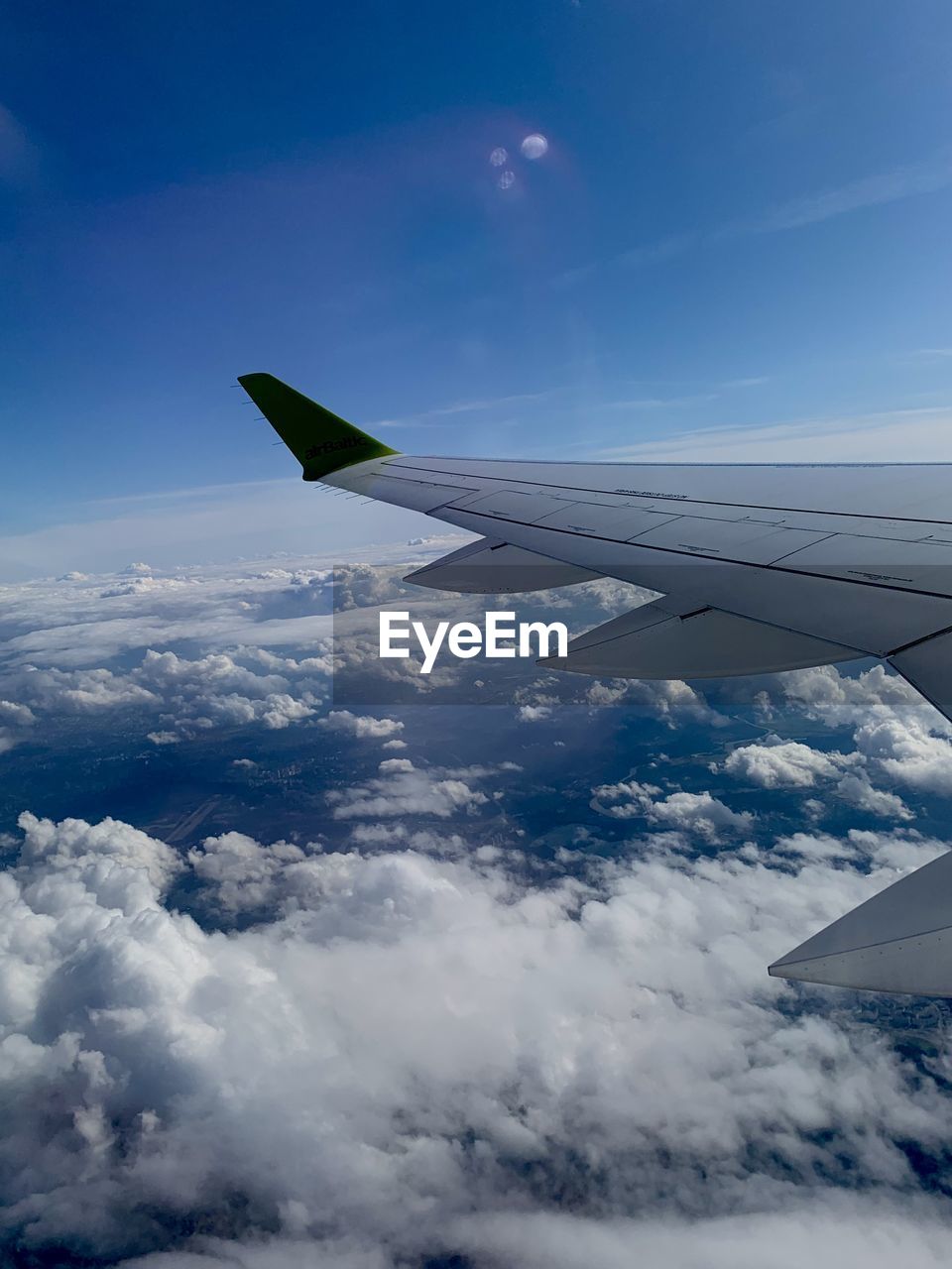 AERIAL VIEW OF AIRPLANE FLYING ABOVE CLOUDS