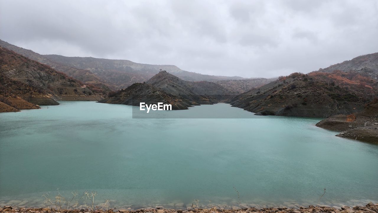 Scenic view of lake and mountains against sky