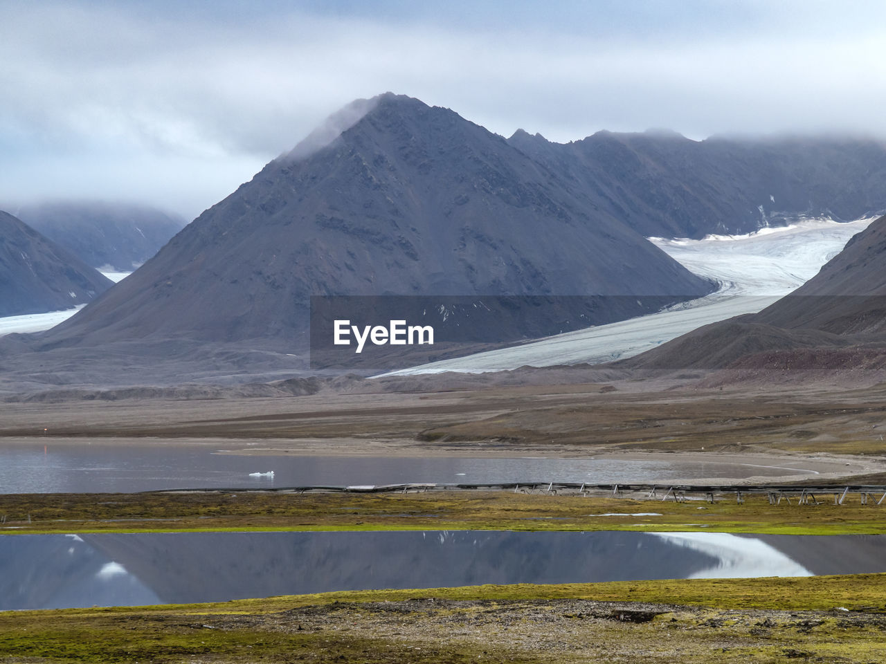 landscape, environment, mountain, scenics - nature, snow, cold temperature, beauty in nature, water, winter, nature, lake, sky, land, mountain range, snowcapped mountain, ice, travel destinations, cloud, travel, tundra, no people, wilderness, non-urban scene, glacier, plateau, tranquility, social issues, tranquil scene, highland, dramatic sky, animal wildlife, tourism, polar climate, environmental conservation, overcast, frozen, outdoors, outdoor pursuit, day, awe, mountain peak, moody sky, remote, rural scene, extreme terrain, nature reserve, ridge, dramatic landscape, pattern, accidents and disasters, environmental issues, natural environment, idyllic, lagoon, distant, reflection