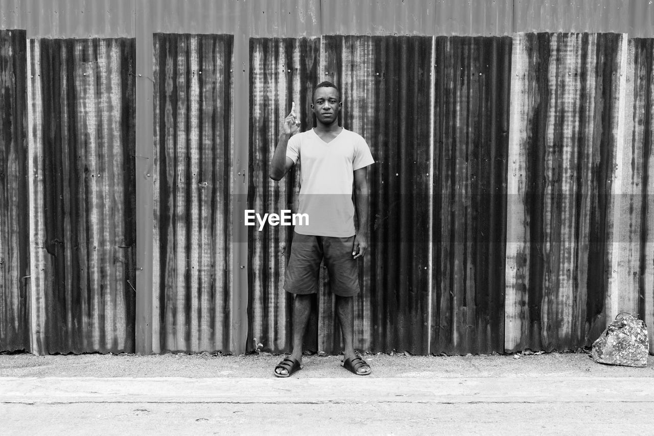 Portrait of man standing against wall