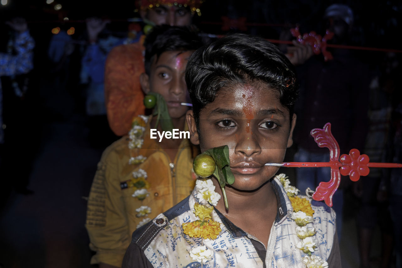 Close-up of boy with pierced metal through cheek during religious festival