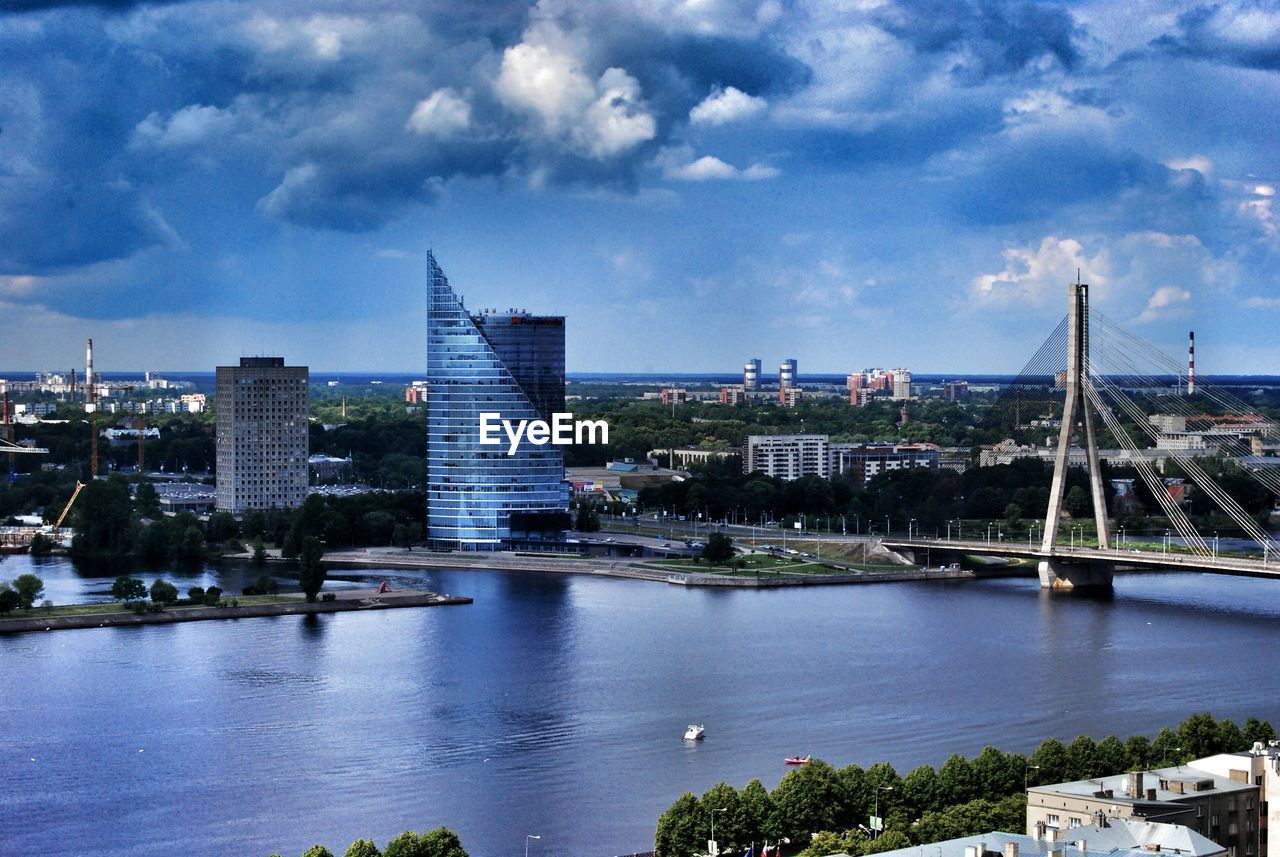 VIEW OF CITYSCAPE WITH RIVER AGAINST CLOUDY SKY