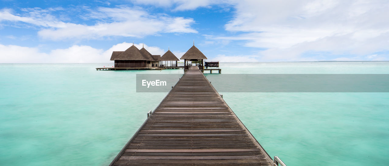 Wooden pier leading towards water bungalows