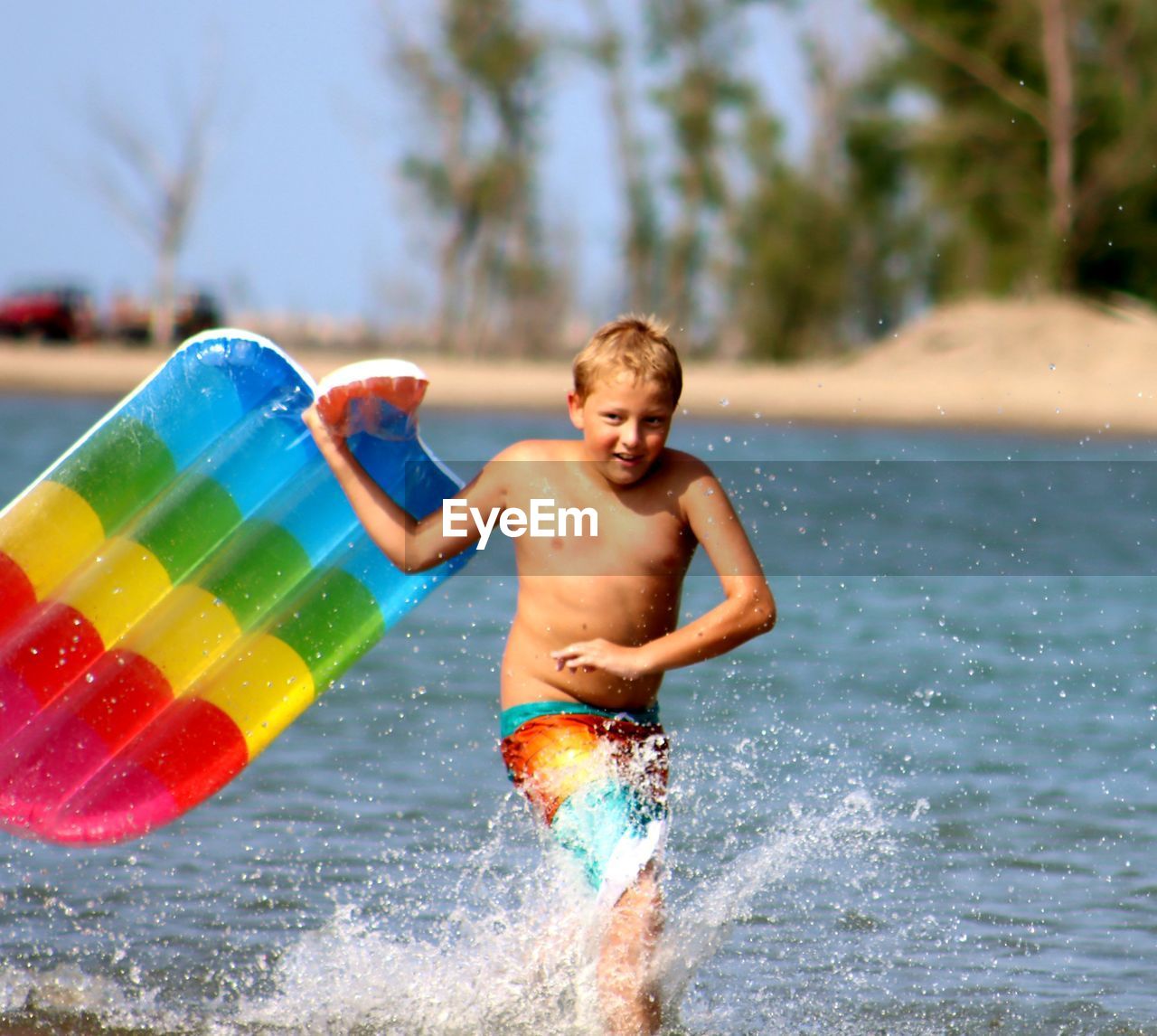 Full length of shirtless boy in lake