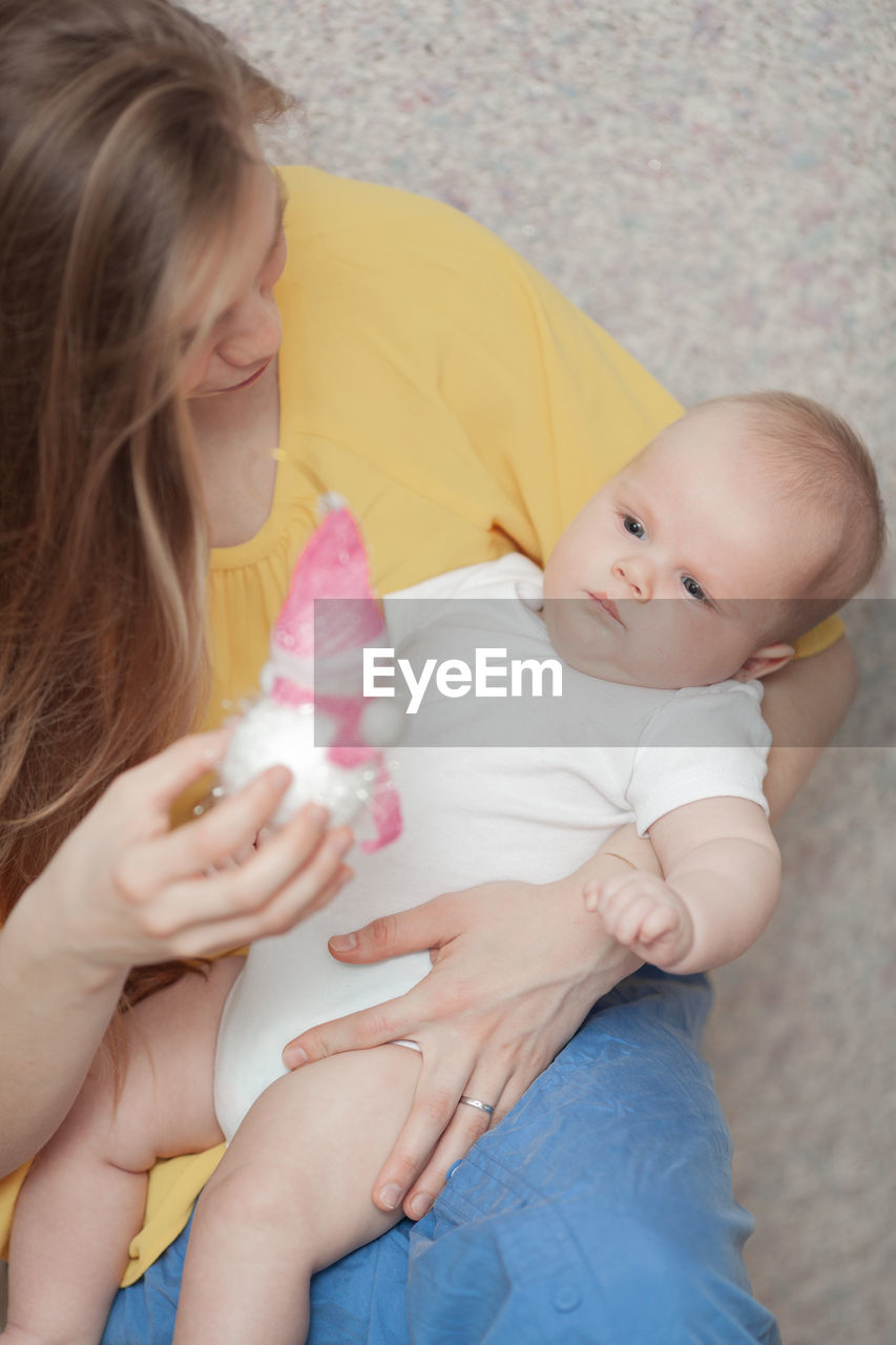 High angle view of mother playing with cute daughter at home