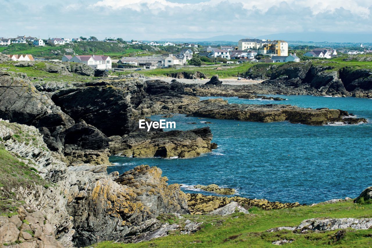 Scenic view of sea by buildings against sky