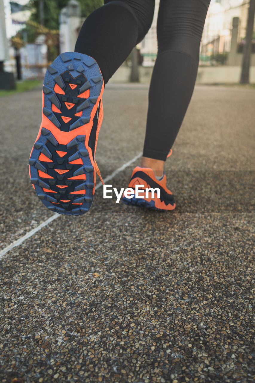 Low section of woman running on road