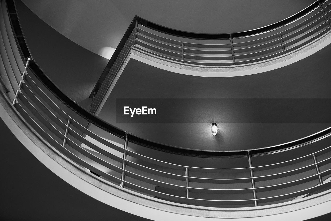 LOW ANGLE VIEW OF PERSON ON STAIRCASE AGAINST BUILDING