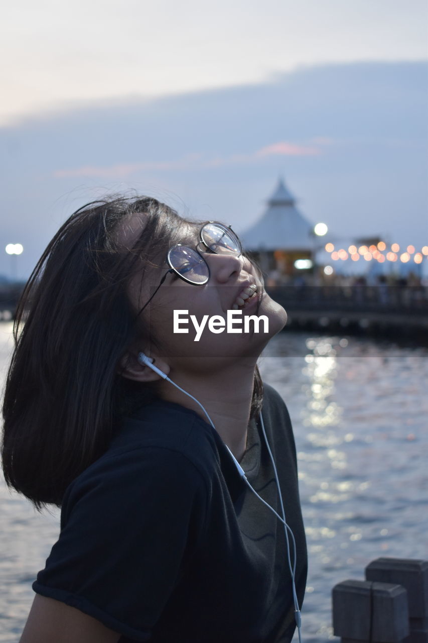 Midsection of woman looking away while standing at shore