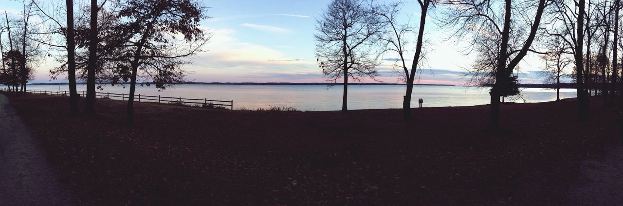 Panoramic view of lake and trees against sky at dusk