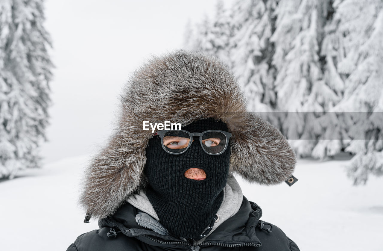 Man with ski mask in winter forest