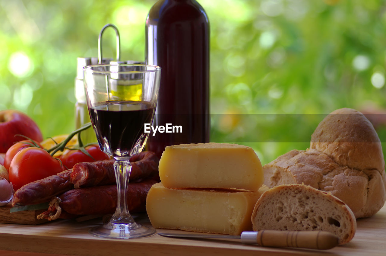 Close-up of wine in glass and cheese on table