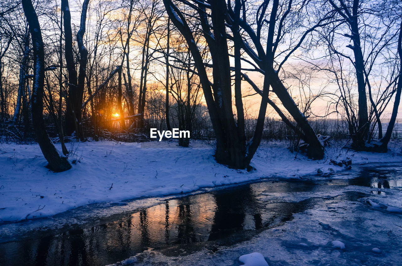 Snow covered field at sunset