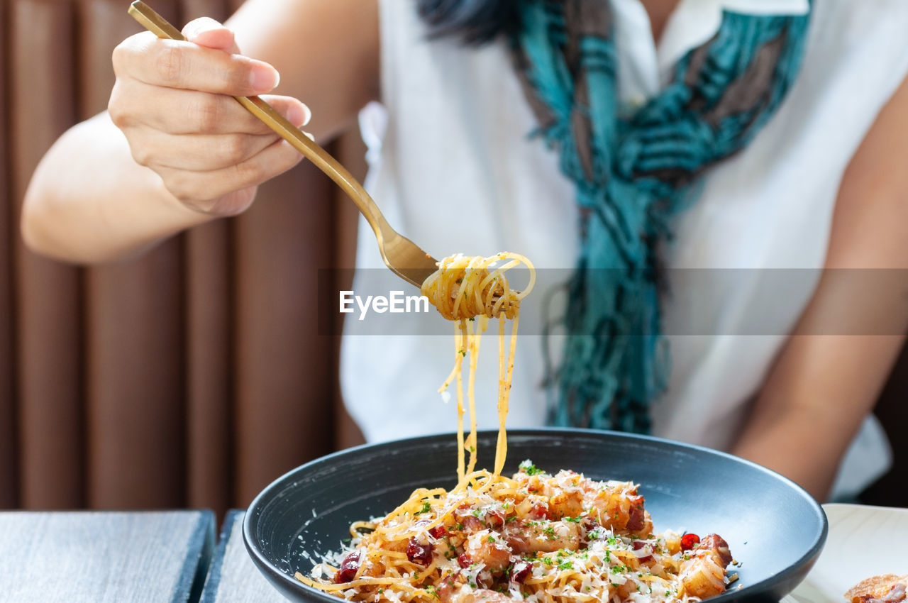 MIDSECTION OF WOMAN HAVING FOOD