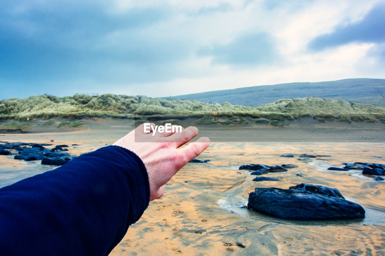 MIDSECTION OF PERSON HAND ON WATER