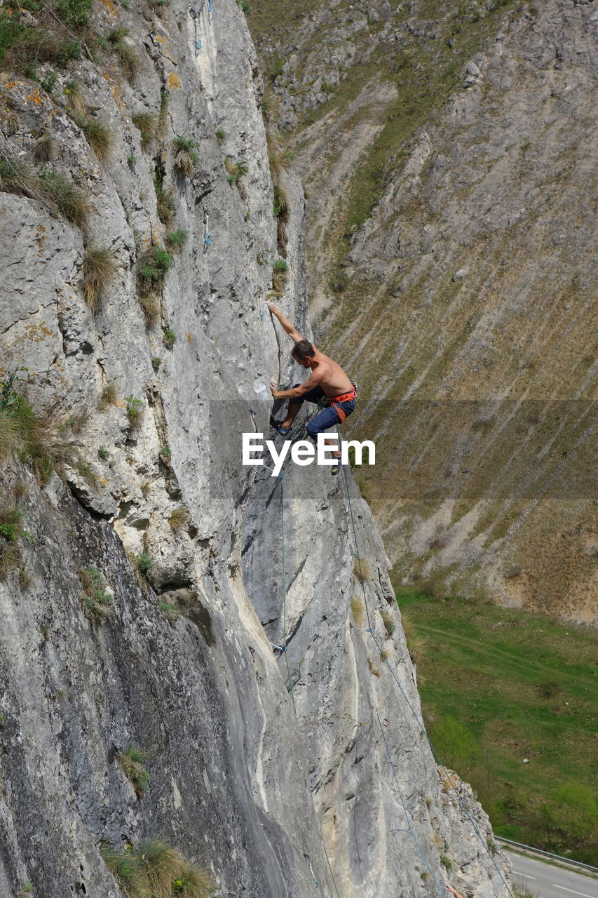 MAN CLIMBING ON ROCK