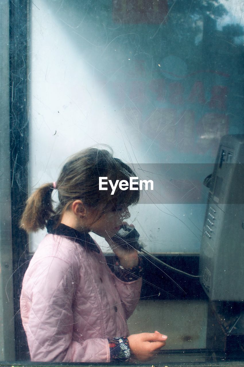 Girl standing in telephone booth