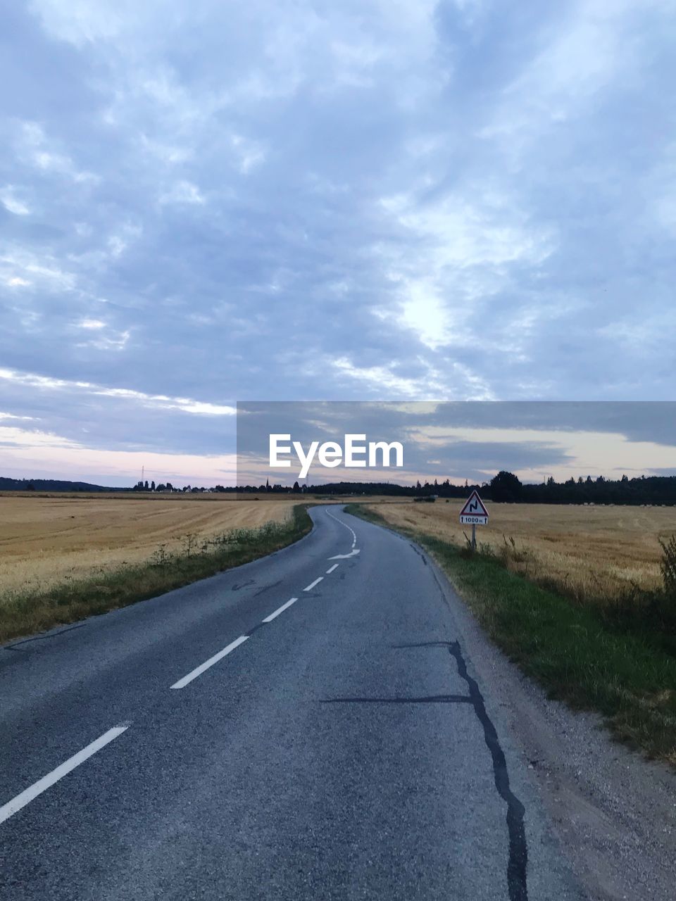 EMPTY ROAD ALONG FIELD