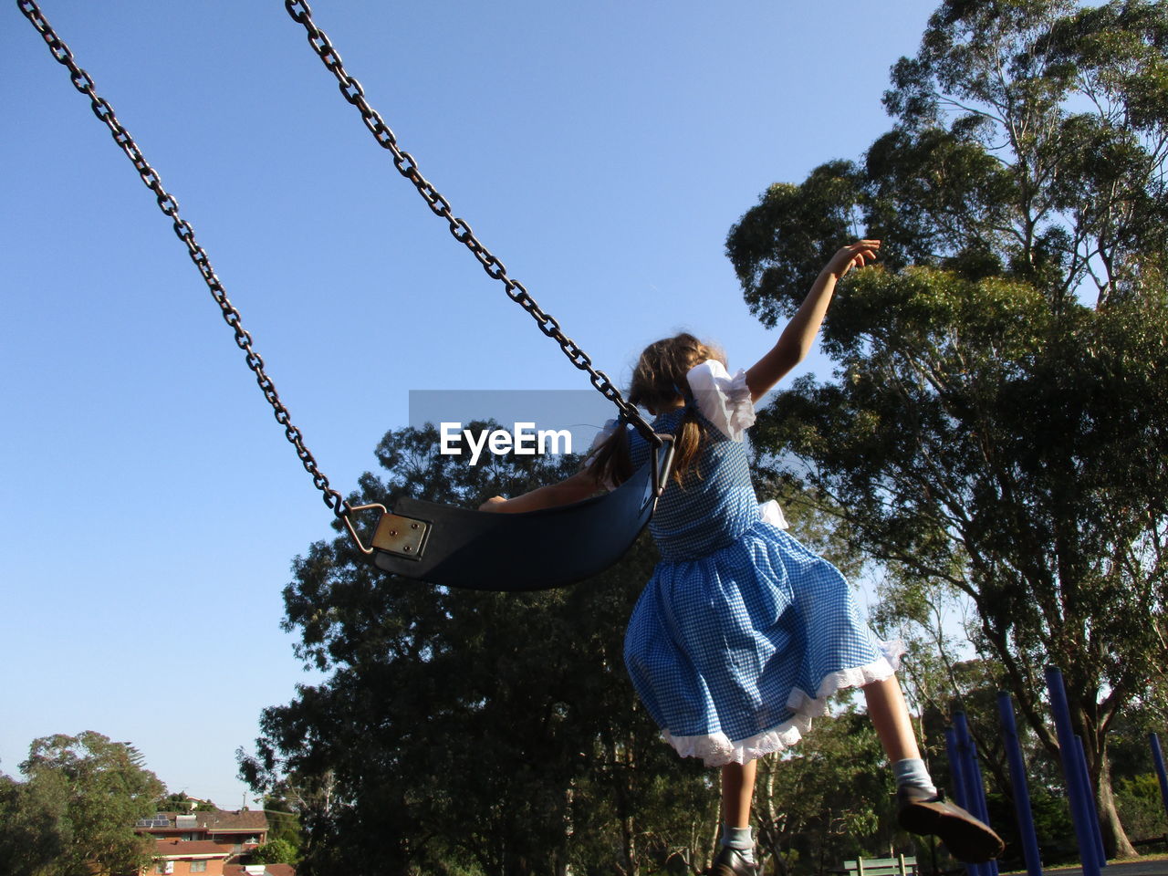 Rear view of girl falling from swing at park