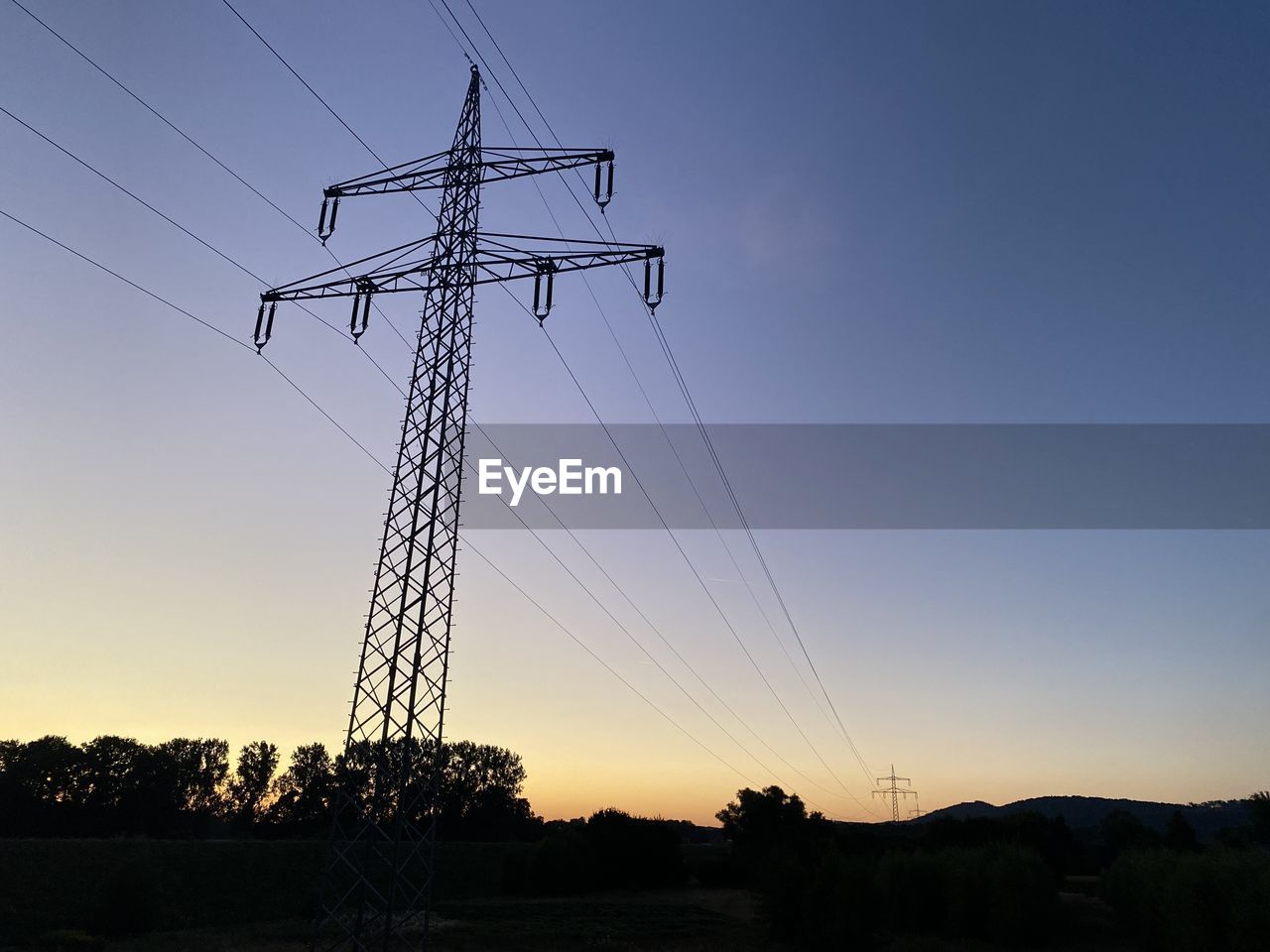 silhouette electricity pylon against clear sky during sunset